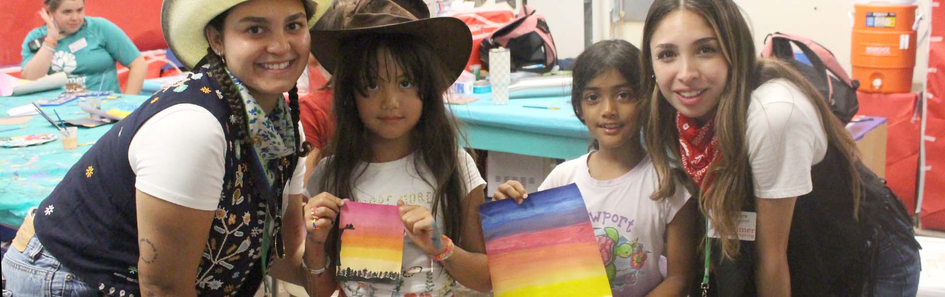 Photo of two girls showing off their paintings